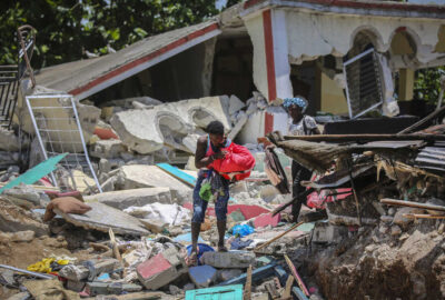 Locals recover their belongings from their homes destroyed in the earthquake in Camp-Perrin, Les Cayes, Haiti, Sunday, Aug. 15, 2021. The death toll from the magnitude 7.2 earthquake in Haiti soared on Sunday as rescuers raced to find survivors amid the rubble ahead of a potential deluge from an approaching tropical storm. (AP Photo/Joseph Odelyn)